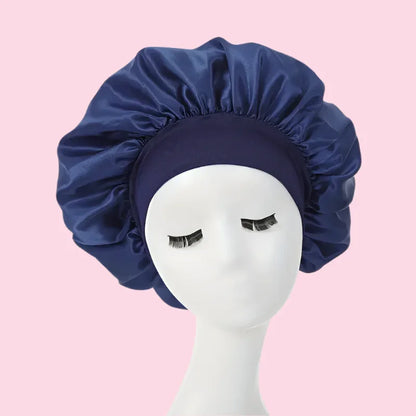 Gorro de satén azul oscuro para el cabello, ideal para cuidado capilar nocturno, fondo rosa.