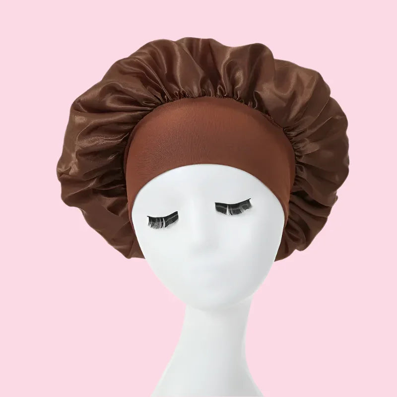 Gorro de satén marrón para el cabello sobre maniquí, fondo rosa, cuidado capilar nocturno