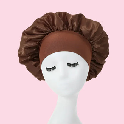 Gorro de satén marrón para el cabello sobre maniquí, fondo rosa, cuidado capilar nocturno