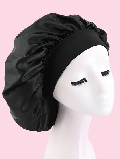 Gorro de satén negro para cuidado del cabello, exhibido en maniquí sobre fondo rosa.
