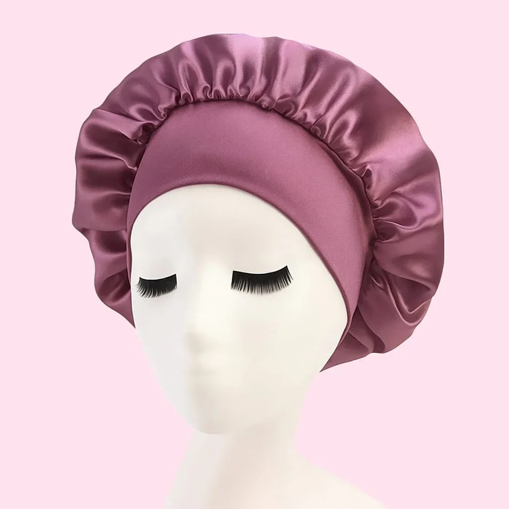 Gorro de satén rosado para el cabello sobre maniquí, ideal para cuidado capilar y skincare.
