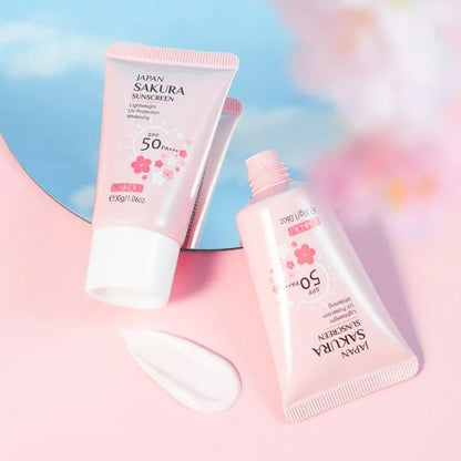 Protector solar facial Sakura SPF 50 PA++ en envases rosas sobre fondo rosa, cosmética coreana.